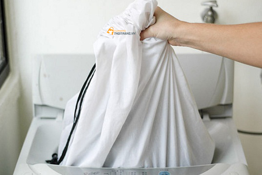 Để áo khoác dạ vào trong túi giặt rồi vứt vào máy giặt