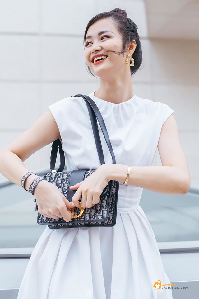 Túi đeo vai Dior nổi bật làm điểm nhấn cho chiếc váy trắng đơn sắc