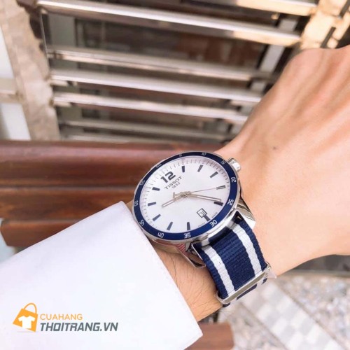 Đồng hồ dây vải Tissot T095.410.17.037.01 với thiết kế hiện đại thời trang dành cho nam, vạch số xanh nổi bật trên nền trắng trang trọng, kết hợp cùng với dây đeo bằng vải trắng xanh tạo nên vẻ thời trang.