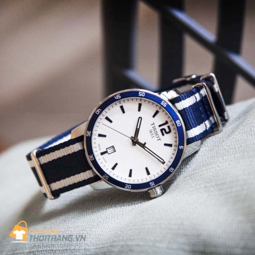 Đồng hồ dây vải Tissot T095.410.17.037.01 với thiết kế hiện đại thời trang dành cho nam, vạch số xanh nổi bật trên nền trắng trang trọng, kết hợp cùng với dây đeo bằng vải trắng xanh tạo nên vẻ thời trang.